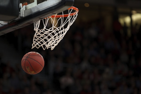 NBA季后赛篮球场上空视角，球员飞身扣篮瞬间，场馆灯光璀璨